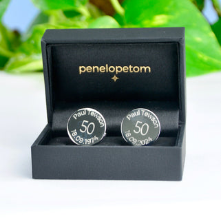 Milestone 50th birthday cufflinks with personalised name and date engraved around the top and bottom, shown in black Penelopetom cufflinks box.