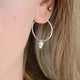 Sterling Silver Hoop Earrings with charm of your choice showing a hoop with acorn close up on model