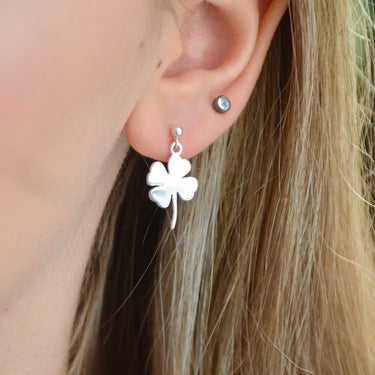 Sterling Silver dangle stud earring with choice of charm shown close up on model with clover charm