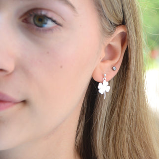 Sterling Silver dangle stud earring with choice of charm shown close up on model with clover charm