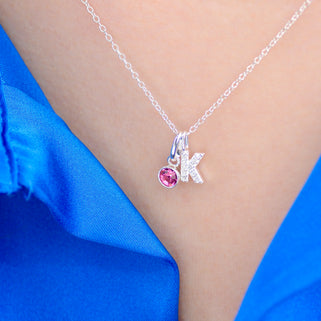 Silver Sparkle K Initial and Alexandrite Birthstone Necklace shown on close up of model