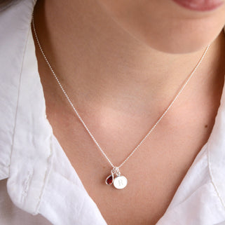 Personalised Silver Girls Initial Teardrop Birthstone Necklace shown close up with  July birthstone