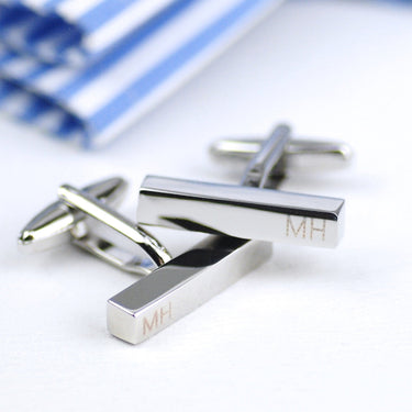 Graduation silver bar cufflinks with initials engraved on both cufflinks shown in closeup shot.