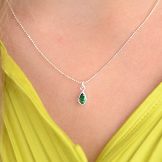 Girl's Sterling Silver Teardrop Birthstone Charm Necklace shown close up with emerald