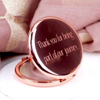 Rose gold compact mirror with personalised text "Thank you for being part of our journey."  engraved on the front, shown in close up shot.