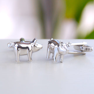 Silver pig cufflinks shown in close up shot