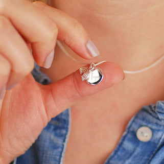 Sterling silver rainbow necklace with personalised circle disc engraved with "Hope" shown in close up shot on model.