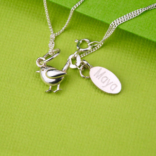 robin charm necklace and personalised disc necklace with "Maya" engraved, close up shot